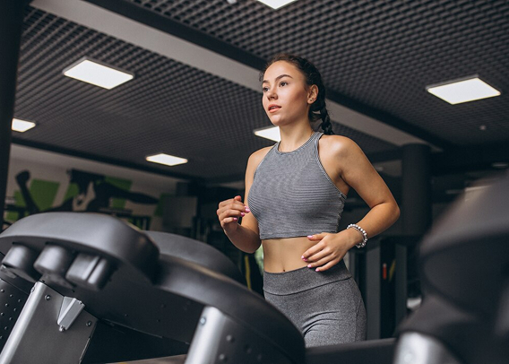 Девушка бежит по беговой дорожке